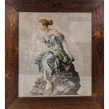 A Victorian embroidered picture with glass beads, depicting Classical woman on the rocks, in