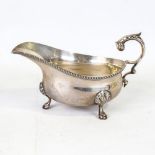 A George V silver sauce boat, gadrooned rim with shell feet and acanthus leaf handle, by