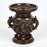 A Chinese patinated bronze urn, circa 1900, high relief cast and moulded surround, height 13.5cm