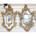 A pair of ornate gilt-framed mirrors, with foliate and floral decoration, height 86cm