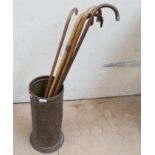 Embossed brass stick stand, containing 5 walking sticks with silver mounts