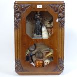 A clock case containing a display of religious items, skull, compass etc, height overall 61cm