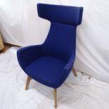 A contemporary designer wing lounge chair upholstered in blue, on splayed legs