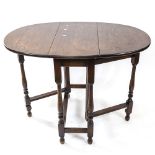 An oak oval drop leaf table on baluster legs, W75cm, H77cm, D32cm