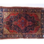 An Antique red ground Hamadan rug, with symmetrical border and lozenge (some damage), 230cm x 146cm