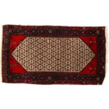A red ground Afghan design wool rug, with symmetrical border and lozenge, 210cm x 130cm