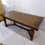A good quality reproduction oak refectory dining table, with carved frieze, baluster turned legs, on