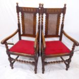 A pair of Carolean style oak elbow chairs, with cane panelled seats and barley twist legs