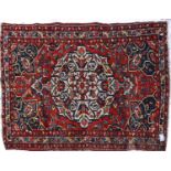 An Antique red ground Hamadan rug, with symmetrical multiple borders and central lozenge, 205cm x