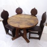 A circular rustic Arts and Crafts style dining table, with 4 matching plank chairs having shaped