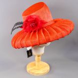 PETER BETTLEY LONDON - Coral red occasion hat, with flower and black feather detail, angled crown,