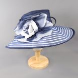 SUZANNE BETTLEY LONDON - Navy blue and white striped occasion hat, with flower and twirl detail,