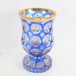 A heavy Bohemian flashed blue overlay glass goblet, gilded instrument and floral decoration, with