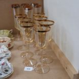 A set of 7 tinted Champagne flutes with gold rims, height 24.5cm, and a set of 7 matching goblets