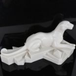 After P Trudeau, an Art Deco style resin sculpture, recumbent panther on geometric base, signed,