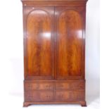 A mahogany 2-section wardrobe, with 2 arch-panelled doors, and a 4-drawer fitted base on bracket