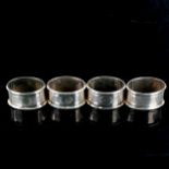 A set of 4 Art Deco George V oval silver napkin rings, engine turned decoration, by Jones &