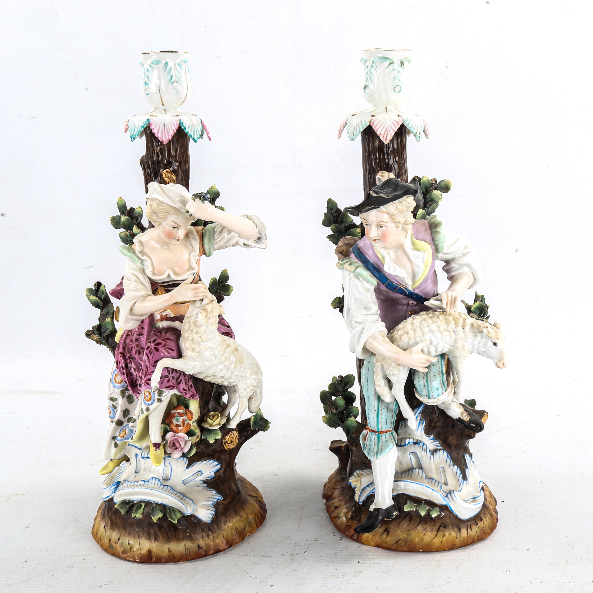 A pair of German porcelain candlesticks, surmounted by shepherd and shepherdess figures, Augustus