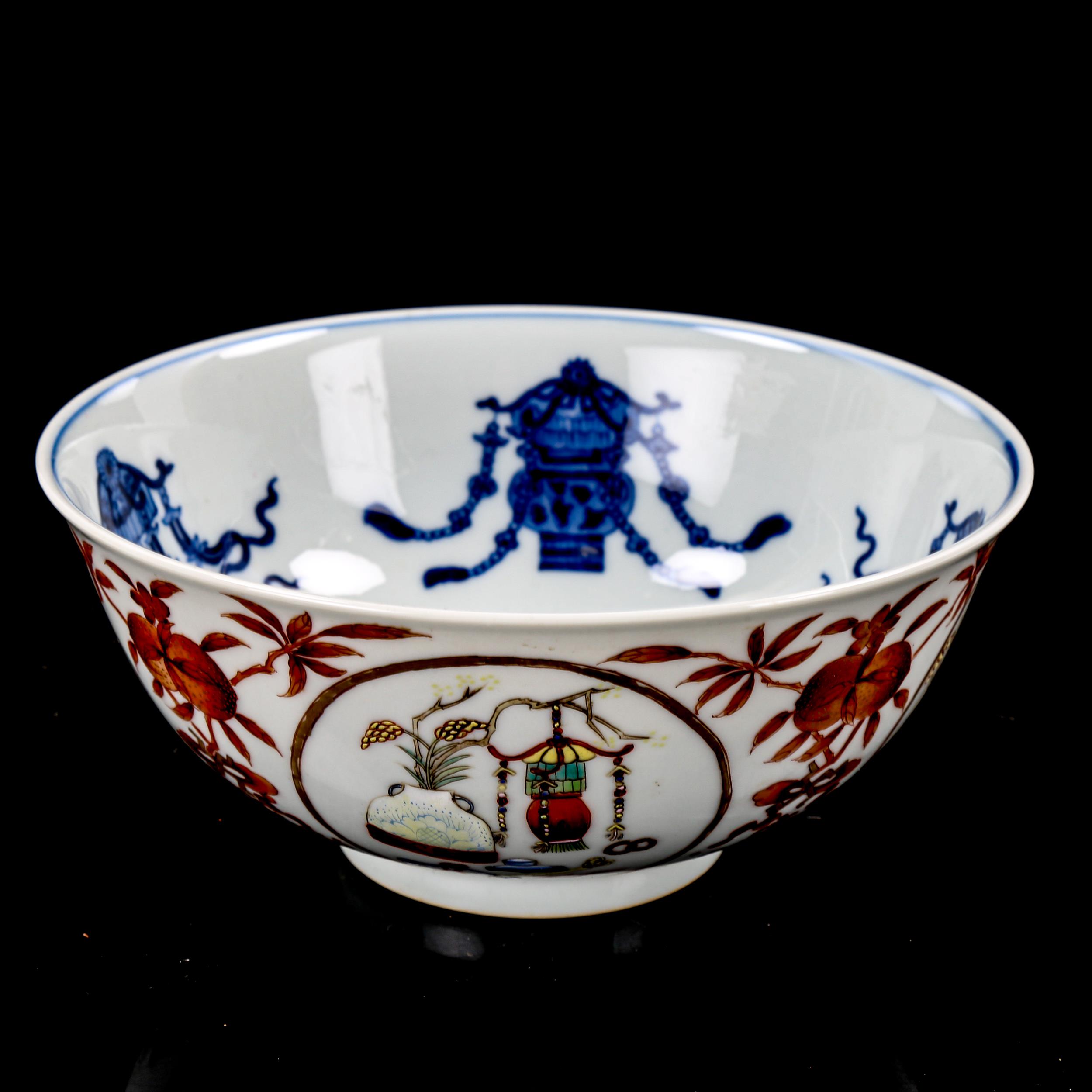 A Chinese porcelain bowl, with painted enamel panels, in iron red surround and blue painted