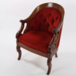 An early 19th century carved walnut-framed library tub chair of small size, with scroll carved arms