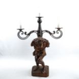 An unusual wrought-iron 3-branch lamp, supported by a carved wood figure of the Quasimodo, height to
