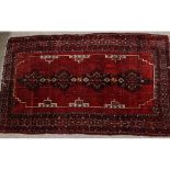 An antique red ground rug, 228 x 137cm