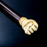 A marine ivory-handled walking stick, carved in the form of a fist holding a snake
