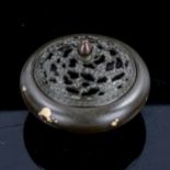A Chinese patinated bronze incense burner, with cast pierced cover, impressed mark under base,