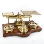 A large pair of Victorian brass parcel scales, on oak base, with original weights (2 x 4lb and set