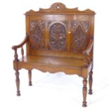 A small size oak settle with acanthus leaf carved panelled back, on turned legs, W95cm, H114cm,