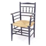 An Antique ebonised Sussex chair with rush seat