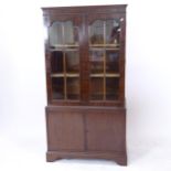 A mahogany bookcase with 2 double arch-top lattice glazed doors, and cupboards under with bracket