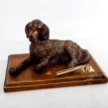 A Black Forest type desk stand, surmounted by a reclining dog, width 25.5cm