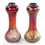 A pair of Loetz style iridescent red glass vases with moulded decoration, hallmarked silver rims,