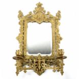 An ornate 19th century relief cast brass-framed wall mirror with candle sconces, overall height 51cm