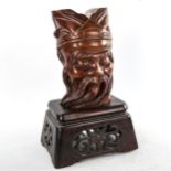 A Chinese carved hardwood head of a man on original carved and pierced wood stand, height 32cm