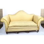 An upholstered sofa, circa 1900, with serpentine-shaped back and rollover arms, on carved feet,