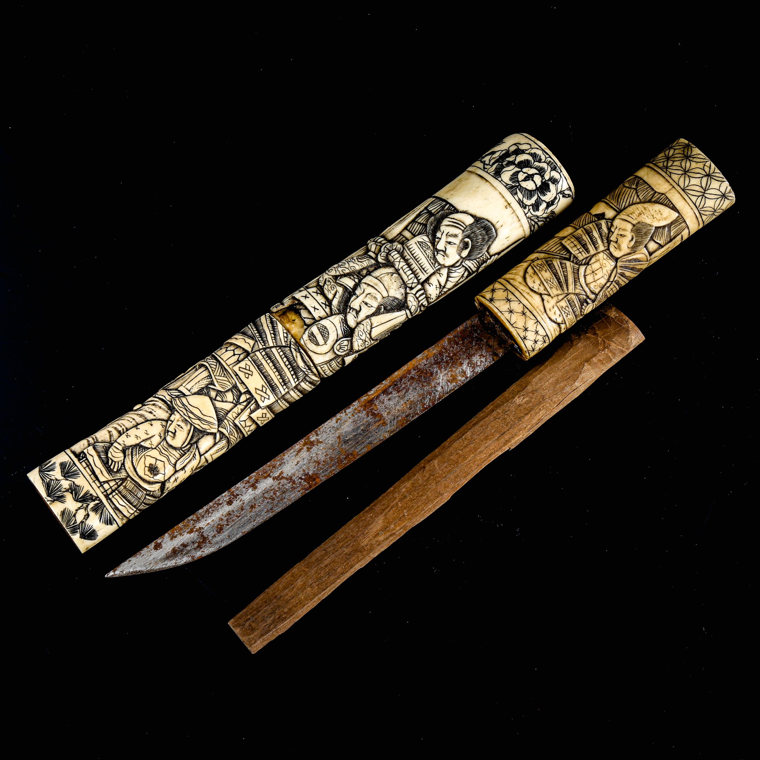 A Japanese relief carved bone dagger, Meiji Period circa 1900, decorated with Samurai Warriors,