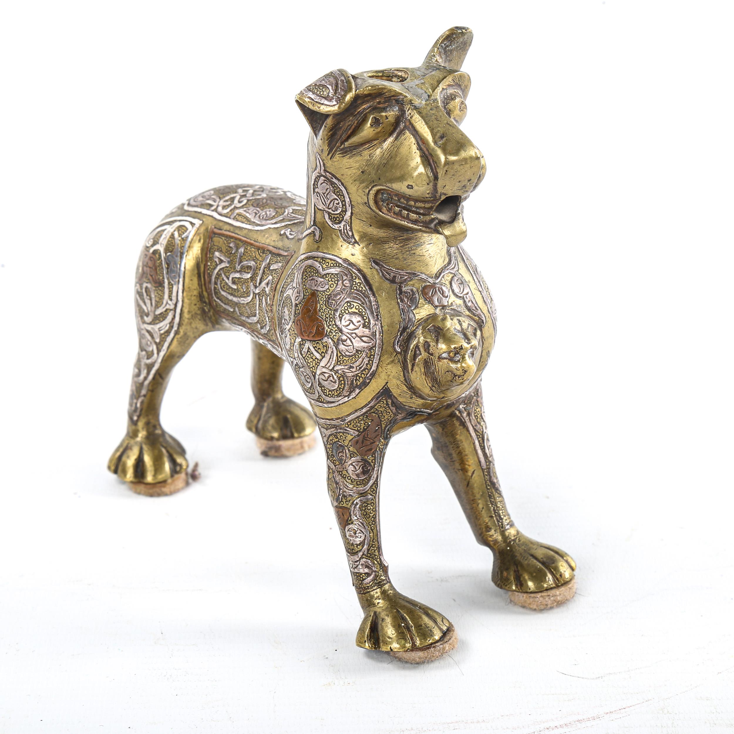 An Islamic bronze standing lion, possibly a lamp base, with inlaid silver and copper decoration - Image 2 of 3
