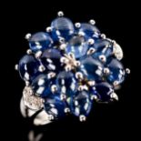 A modern 9ct white gold sapphire and diamond cluster dress ring, set with oval cabochon sapphires