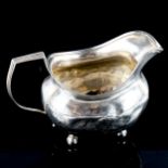 A George III silver cream jug, bright-cut engraved floral decoration with gilt interior and bun