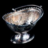 A late Victorian silver pedestal sugar bowl, relief embossed foliate decoration with swing handle