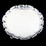 A George VI circular silver salver, scalloped rim with scrolled acanthus leaf feet, by William