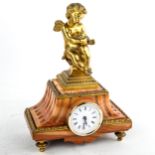 An early 20th century French red marble-cased mantel clock, surmounted by gilt-bronze cherub,