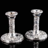 A pair of Elizabeth II silver filled squat table candlesticks, allover relief embossed foliate