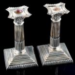 ASPREY - a pair of George V silver squat Corinthian column table candlesticks, with removable