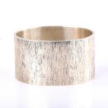 An Elizabeth II heavy gauge oval silver napkin ring, textured bark design, by S J Rose & Son,