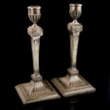 A pair of Dutch silver table candlesticks, fluted decoration with relief embossed roundels and