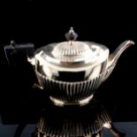 A late Victorian silver teapot, oval half fluted form with turned ebony mounts, by John Round & Sons