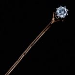 An early 20th century solitaire diamond stickpin, unmarked gold settings with a 0.2ct modern round